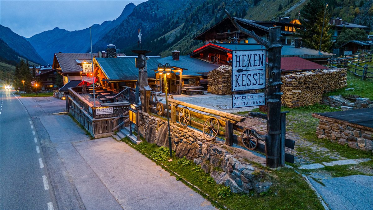 Gastronomie-Gebäude in alpiner Landschaft zur blauen Stunde